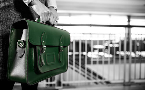 Image: an attorney holding a green briefcase